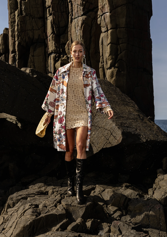 Girl wearing the Phoenix Kimono with peach and green bird motifs, photographed in the rocky shores Lisbon, Portugal – cultural craftsmanship by My Paloma.