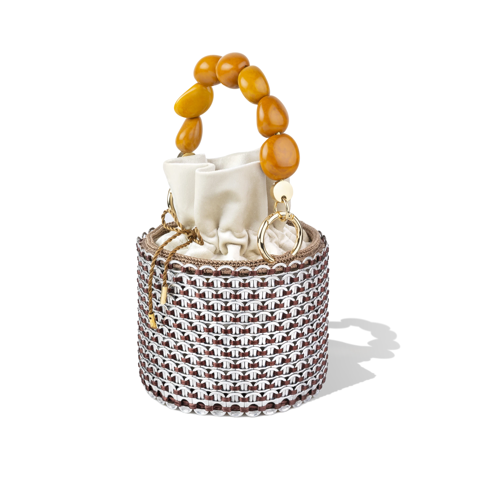 Side profile of the Alex Bucket Bag showing off its cylindrical form, golden beaded handle, and semi-transparent lattice detailing.