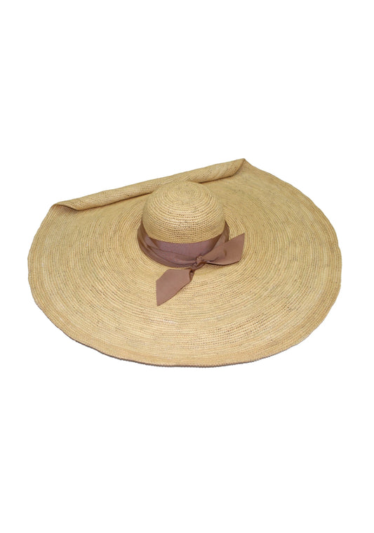 Flat-lay of the Crochet Glamour Hat revealing the full circular shape and tied ribbon detail.