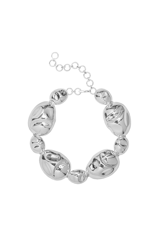 Sculptural statement necklace in silver-plated brass with bold interlocking forms and an adjustable hook closure.