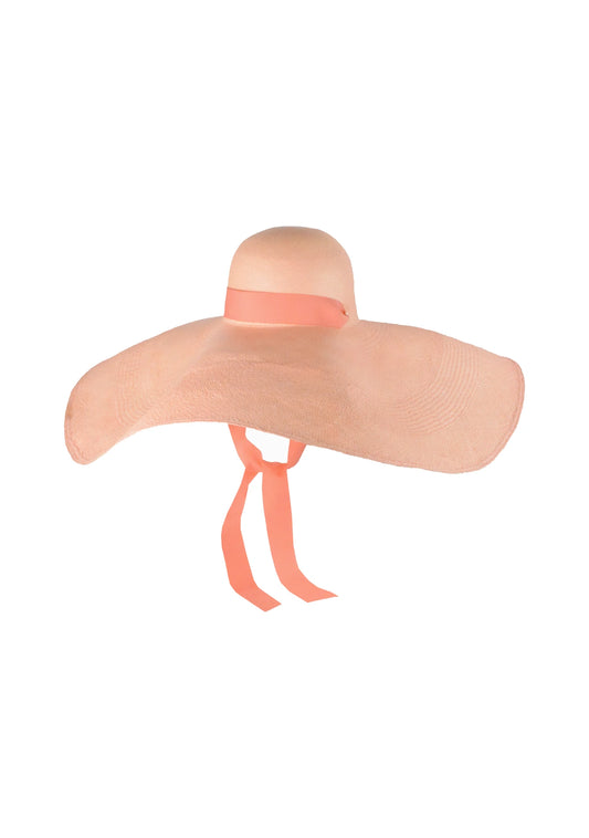 Product image of the Lady Ibiza Hat in blush pink, featuring an exaggerated wide brim and soft dome crown with matching ribbon ties—crafted from fine straw for a dramatic, feminine silhouette.