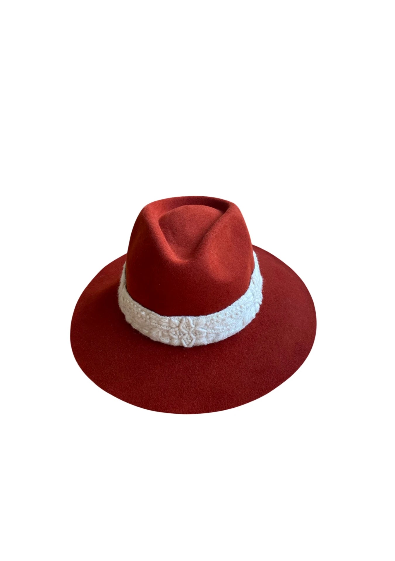 Flat lay of a brick red wool-felt fedora with a thick white embroidered band, highlighting the detailed crown and brim
